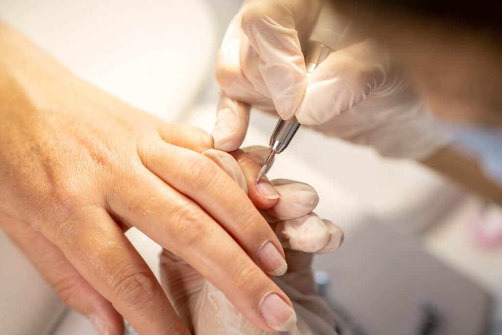 De nagelriemen van een hand worden bijgewerkt aan de behandeltafel in de salon